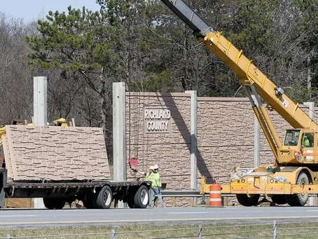 noise wall being moved into place by a crane